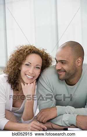 Stock Photography - African couple laying on floor. Fotosearch