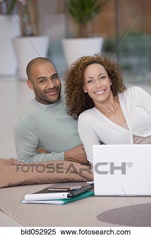 Stock Photography - African couple working on floor. Fotosearch