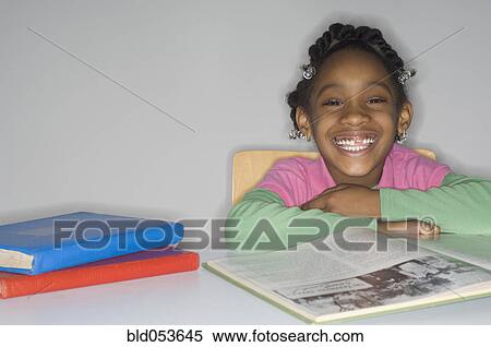 African girl at table with school books View Large Photo Image Stock Photography - African girl at table with school books. Fotosearch