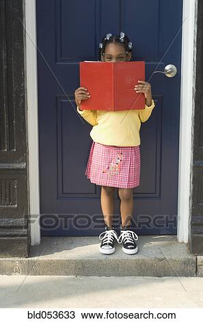 African girl holding book in doorway View Large Photo Image Stock Image - African girl holding book in doorway. Fotosearch