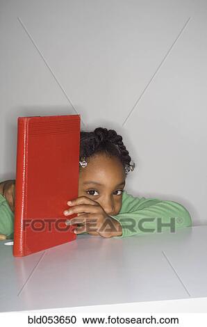 Stock Image - African girl holding book. Fotosearch