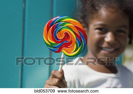 African girl holding lollipop View Large Photo Image Stock Photo - African girl holding lollipop. Fotosearch