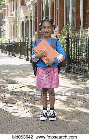 Stock Image - African girl holding school books. Fotosearch