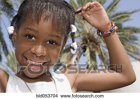 Picture - African girl pulling on braid. Fotosearch