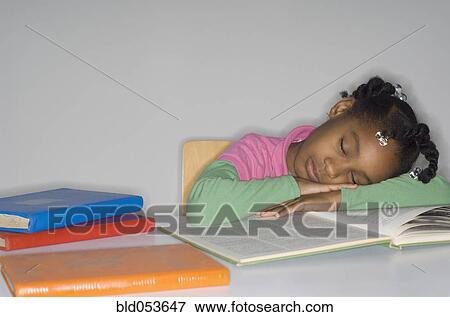 Stock Photo - African girl sleeping on open book. Fotosearch