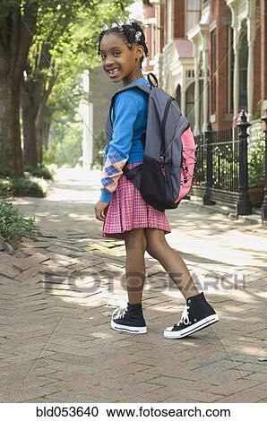 Stock Image - African girl wearing backpack. Fotosearch