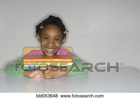Stock Photo - African girl with stack of school books. Fotosearch