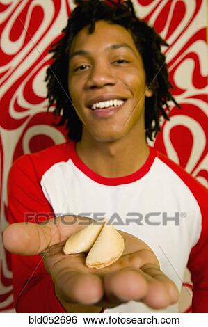 African man holding fortune cookie View Large Photo Image Stock Photograph - African man holding fortune cookie. Fotosearch