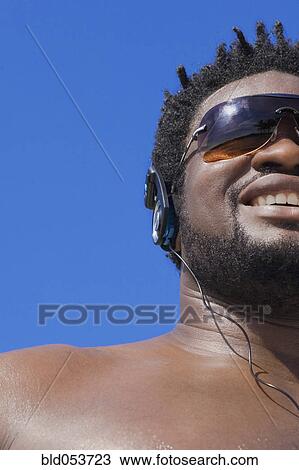 Stock Image - African man listening to headphones. Fotosearch