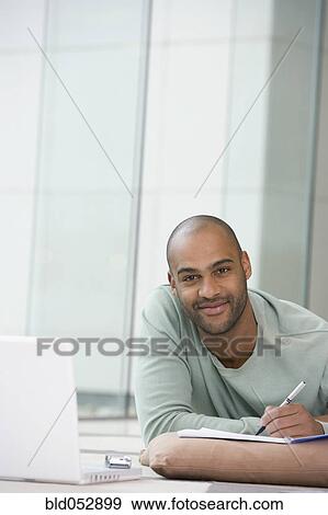 African man writing on notepad View Large Photo Image Stock Photo - African man writing on notepad. Fotosearch