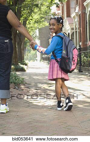 Stock Image - African mother and daughter holding hands. Fotosearch