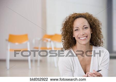 Stock Image - African woman holding pen. Fotosearch