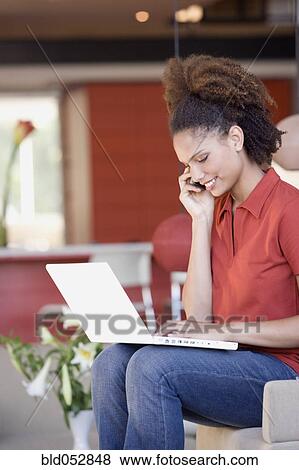 Stock Photo - African woman typing on laptop. Fotosearch