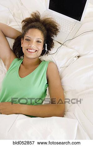 Stock Photo - African woman wearing hands-free device. Fotosearch