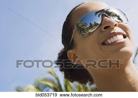 Stock Photo - African woman wearing mirrored sunglasses. Fotosearch