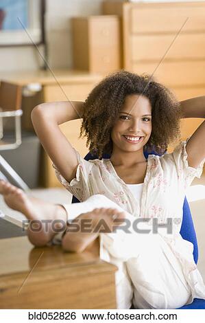 African woman with feet up on desk View Large Photo Image Stock Photograph - African woman with feet up on desk. Fotosearch