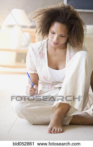 African woman writing on note pad View Large Photo Image Stock Image - African woman writing on note pad. Fotosearch