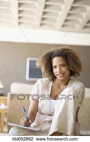 African woman writing on note pad View Large Photo Image Stock Image - African woman writing on note pad. Fotosearch