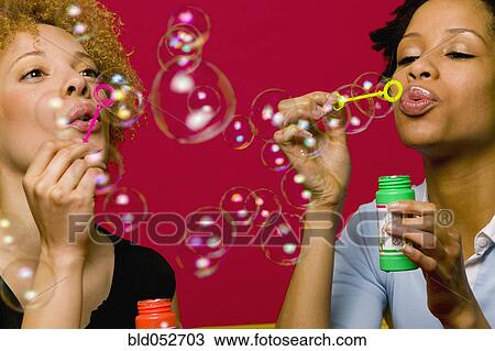 Stock Image - African women blowing bubbles. Fotosearch