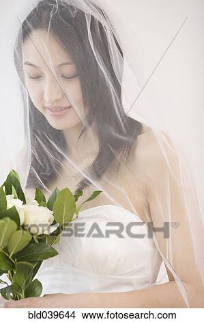 Asian bride holding flower bouquet View Large Photo Image Picture - Asian bride holding flower bouquet. Fotosearch