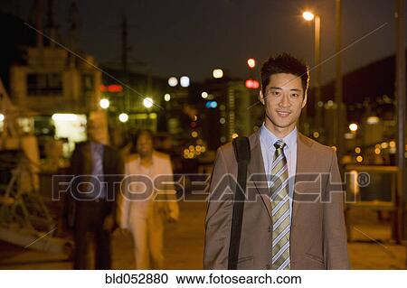 Asian businessman outdoors at night View Large Photo Image Stock Image - Asian businessman outdoors at night. Fotosearch
