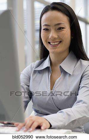 Asian businesswoman typing on computer View Large Photo Image Stock Image - Asian businesswoman typing on computer. Fotosearch