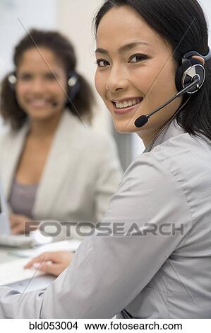 Picture - Asian businesswoman wearing headset. Fotosearch