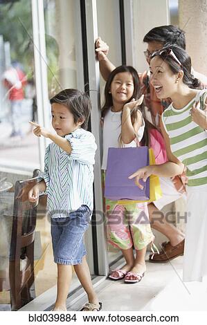 Picture - Asian family window shopping. Fotosearch