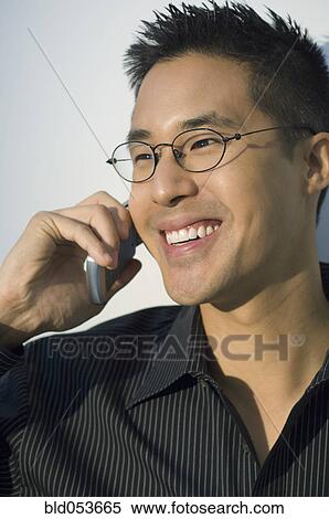 Asian man talking on cell phone View Large Photo Image Stock Photography - Asian man talking on cell phone. Fotosearch
