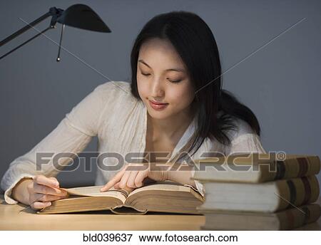 Asian woman reading at desk View Large Photo Image Stock Photo - Asian woman reading at desk. Fotosearch