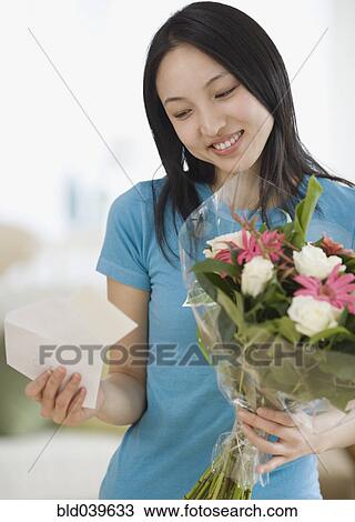 Stock Image - Asian woman receiving flowers. Fotosearch