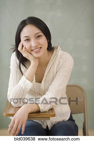 Asian woman sitting at school desk View Large Photo Image Stock Photo - Asian woman sitting at school desk. Fotosearch