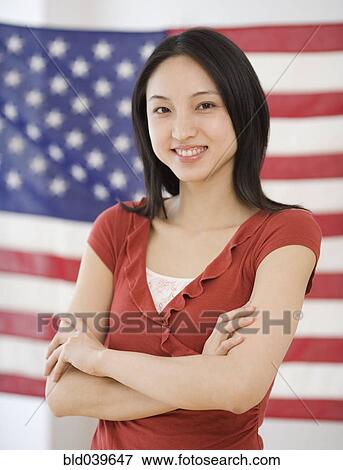 Asian woman standing in front of American flag View Large Photo Image Stock Photo - Asian woman standing in front of American flag. Fotosearch