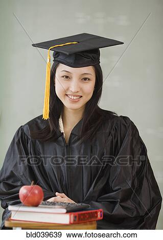 Asian woman wearing graduation cap and gown View Large Photo Image Stock Photo - Asian woman wearing graduation cap and gown. Fotosearch