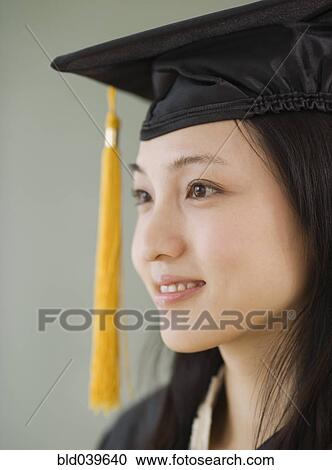 Stock Image - Asian woman wearing graduation cap. Fotosearch