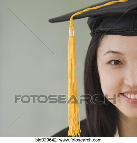 Stock Image - Asian woman wearing graduation cap. Fotosearch