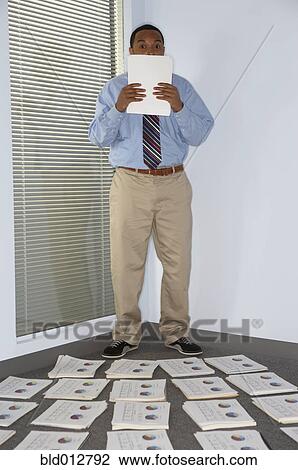 Stock Image - Business man surrounded by reports. Fotosearch