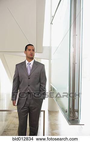 Businessman carrying laptop computer View Large Photo Image Picture - Businessman carrying laptop computer. Fotosearch