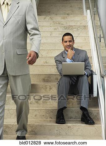 Businessman sitting on steps with laptop View Large Photo Image Stock Photo - Businessman sitting on steps with laptop. Fotosearch