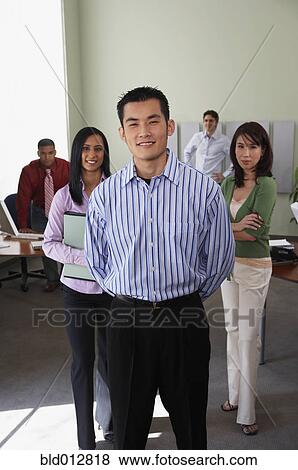 Businessman with coworkers in background View Large Photo Image Stock Photo - Businessman with coworkers in background. Fotosearch