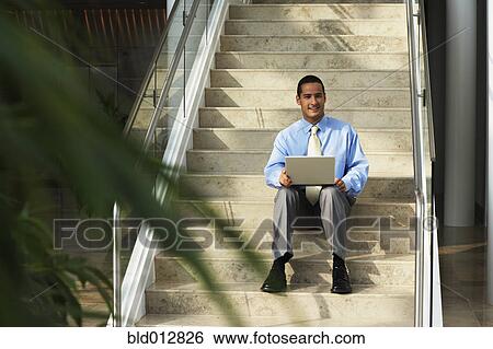Businessman with laptop sitting on step View Large Photo Image Stock Photograph - Businessman with laptop sitting on step. Fotosearch