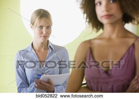 Stock Image - Businesswoman with coworker in foreground. Fotosearch