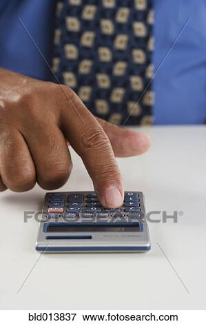 Close up of businessman's hand using calculator View Large Photo Image Stock Photo - Close up of businessman's hand using calculator. Fotosearch