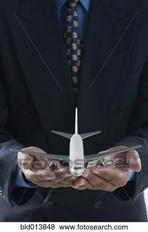 Stock Photo - Close up of businessman's hands holding toy airplane . Fotosearch