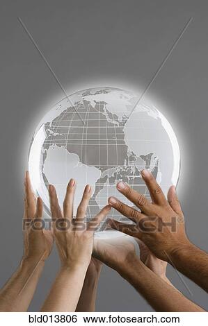 Stock Photograph - Close up of group of hands holding globe. Fotosearch