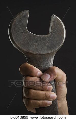 Stock Photography - Close up of hand holding wrench. Fotosearch