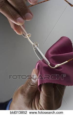 Stock Image - Close up of hands cleaning glasses. Fotosearch