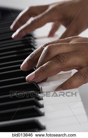Stock Photograph - Close up of hands playing piano . Fotosearch