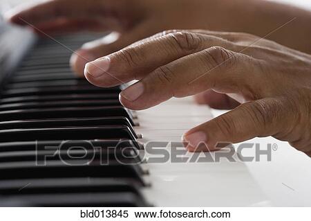 Stock Photography - Close up of hands playing piano. Fotosearch