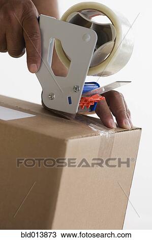 Close up of hands taping up box View Large Photo Image Stock Image - Close up of hands taping up box. Fotosearch